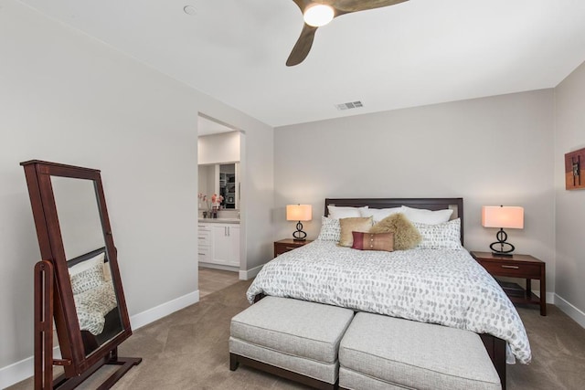 carpeted bedroom with ensuite bath and ceiling fan