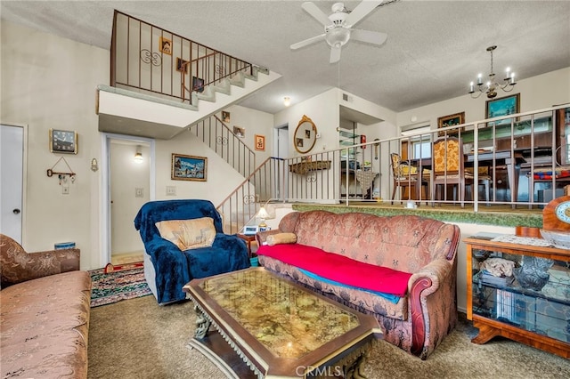 living room featuring ceiling fan with notable chandelier, a textured ceiling, and carpet