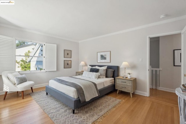 bedroom with ornamental molding and light hardwood / wood-style flooring