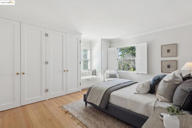 bedroom featuring ornamental molding and light hardwood / wood-style flooring