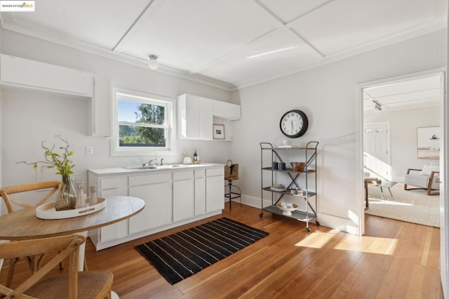 kitchen with white cabinets, light hardwood / wood-style floors, and sink