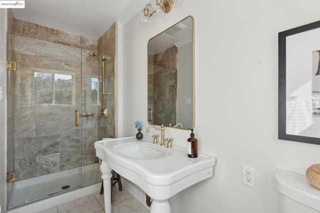 bathroom with toilet, tile patterned flooring, and a shower with shower door