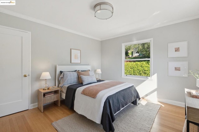 bedroom with ornamental molding and light hardwood / wood-style floors