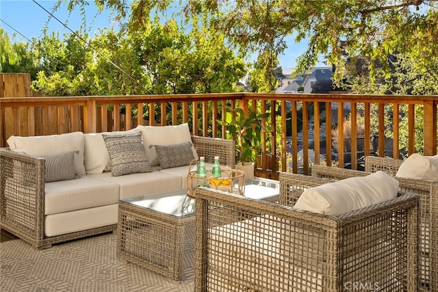 wooden terrace with an outdoor living space