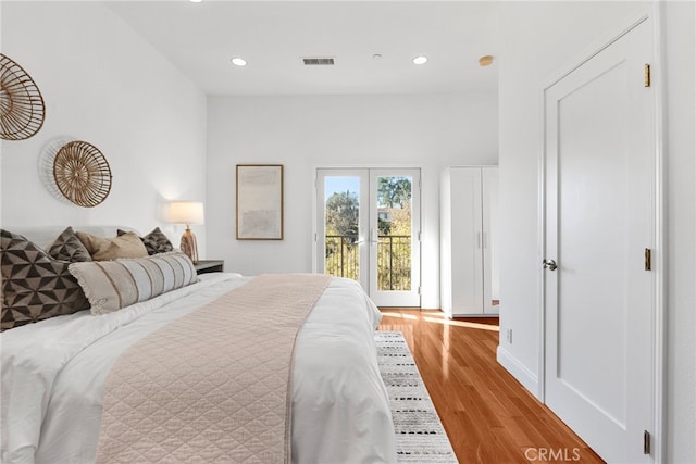 bedroom featuring french doors, light hardwood / wood-style floors, and access to outside