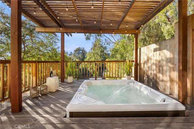 deck featuring an outdoor hot tub and a pergola