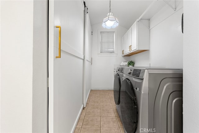 washroom with cabinets, light tile patterned flooring, and washer and dryer