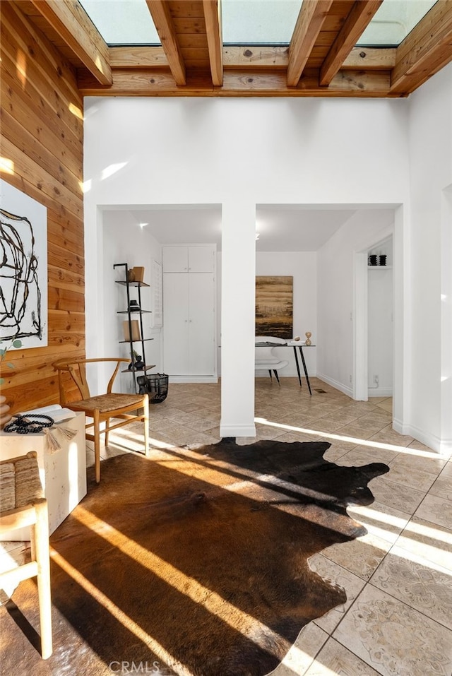 exercise area with wooden ceiling, a skylight, and wood walls