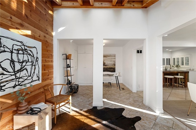 workout area featuring wooden walls, tile patterned flooring, and a high ceiling