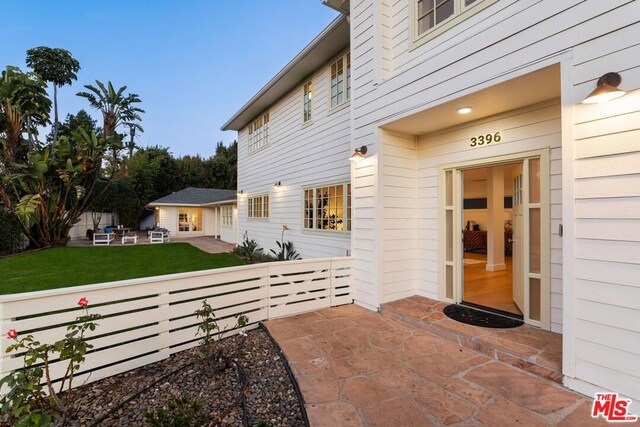 entrance to property with a lawn