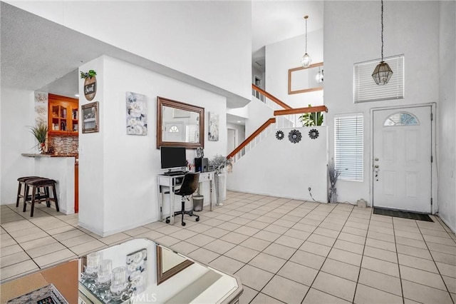 tiled entrance foyer featuring a high ceiling