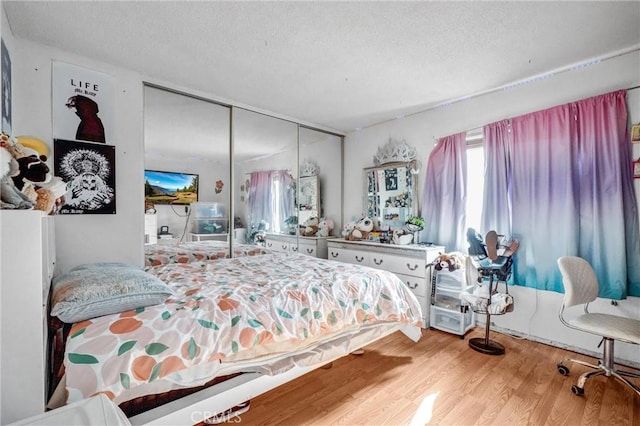 bedroom featuring a closet, a textured ceiling, and hardwood / wood-style flooring