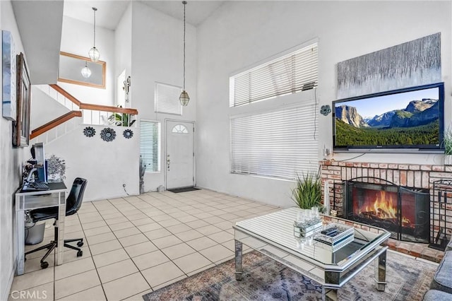 tiled living room with a brick fireplace and a high ceiling