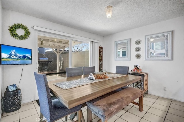 tiled dining space with a textured ceiling