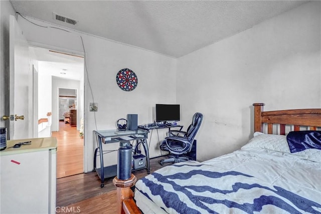 bedroom featuring dark hardwood / wood-style floors and a textured ceiling