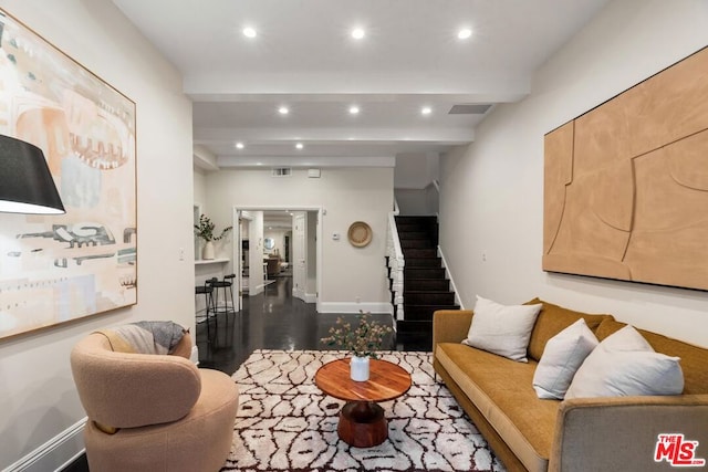 living room with dark wood-type flooring and beamed ceiling