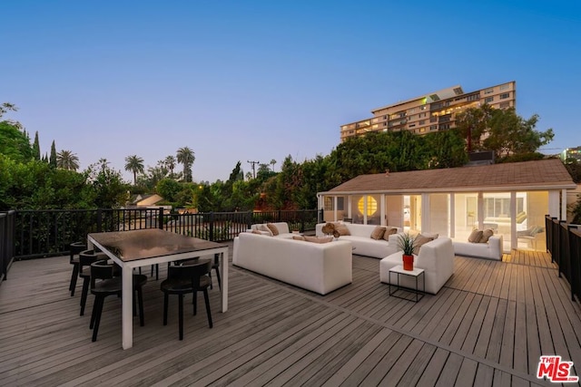 deck at dusk featuring an outdoor hangout area