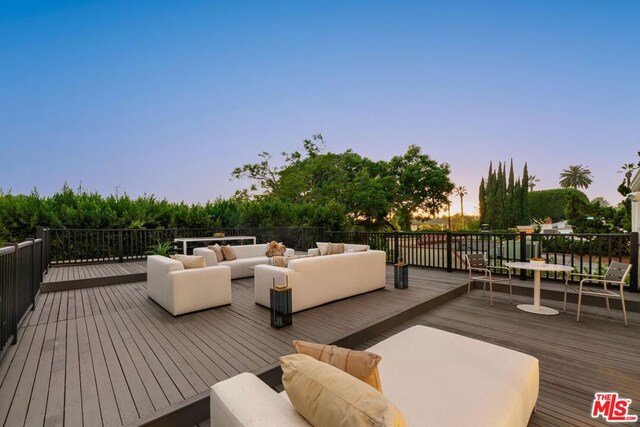 deck at dusk featuring an outdoor hangout area