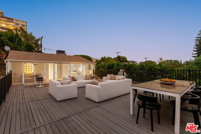 deck at dusk featuring an outdoor hangout area