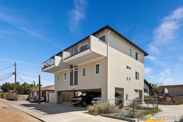 view of side of home with a balcony and a carport