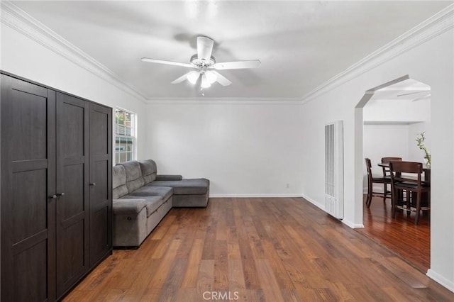 sitting room with dark wood-type flooring, ceiling fan, and ornamental molding