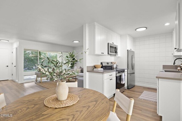 dining room with light hardwood / wood-style flooring and sink