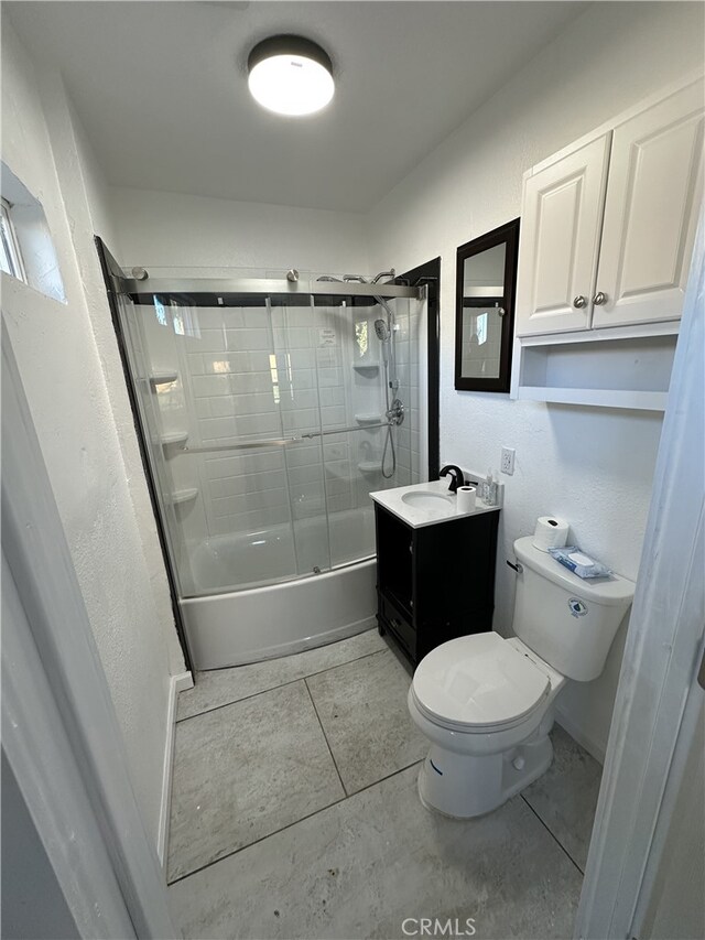 full bathroom with toilet, bath / shower combo with glass door, tile patterned floors, and vanity