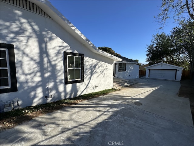 view of property exterior with a garage and an outbuilding