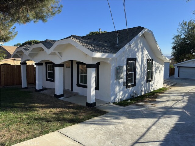 view of front facade featuring an outbuilding, a front yard, and a garage