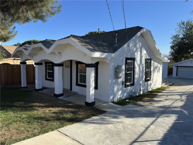 view of front of property with a front yard, a garage, and an outdoor structure