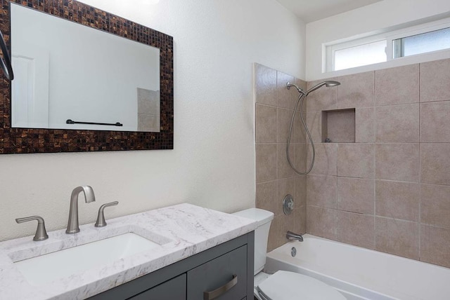 full bathroom with tiled shower / bath combo, vanity, and toilet