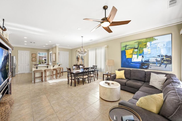 living room featuring ceiling fan with notable chandelier, light tile patterned floors, crown molding, and a healthy amount of sunlight