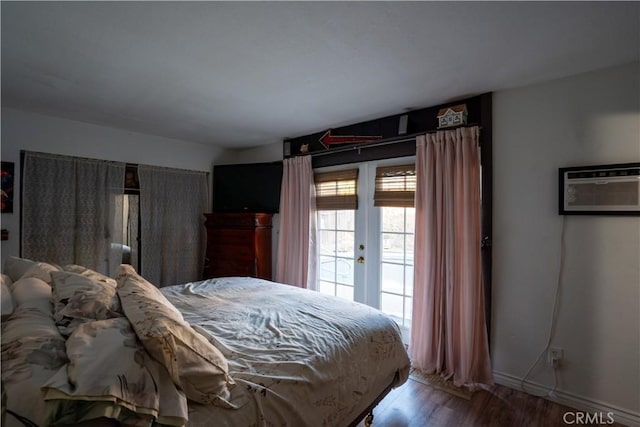 bedroom with hardwood / wood-style flooring, french doors, access to outside, and a wall mounted AC