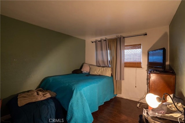 bedroom with dark hardwood / wood-style floors