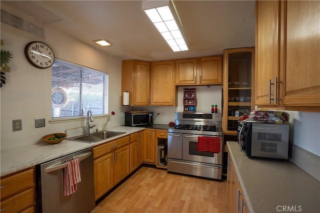 kitchen with stainless steel appliances, light hardwood / wood-style floors, and sink