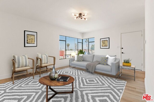 living room with an inviting chandelier and light hardwood / wood-style flooring