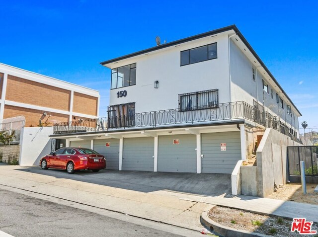 back of property with a garage and a balcony