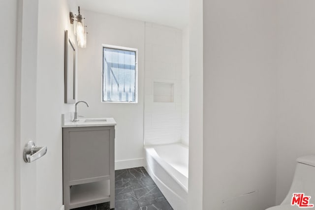 bathroom featuring toilet, vanity, and a washtub