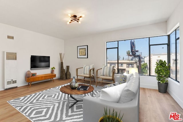 living room with an inviting chandelier and light hardwood / wood-style floors