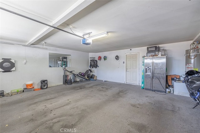 garage featuring water heater, refrigerator with ice dispenser, and a garage door opener