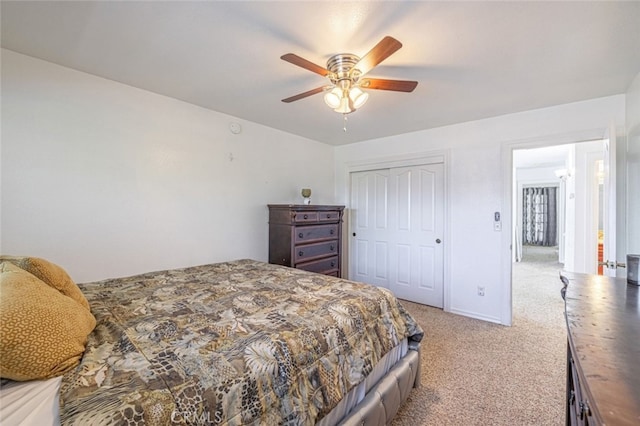 carpeted bedroom featuring ceiling fan and a closet