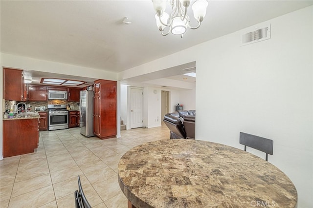 dining space featuring an inviting chandelier, light tile patterned floors, and sink