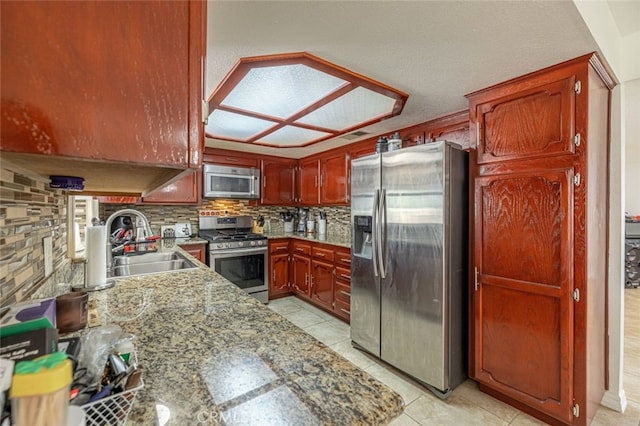 kitchen with decorative backsplash, sink, appliances with stainless steel finishes, light tile patterned floors, and light stone counters