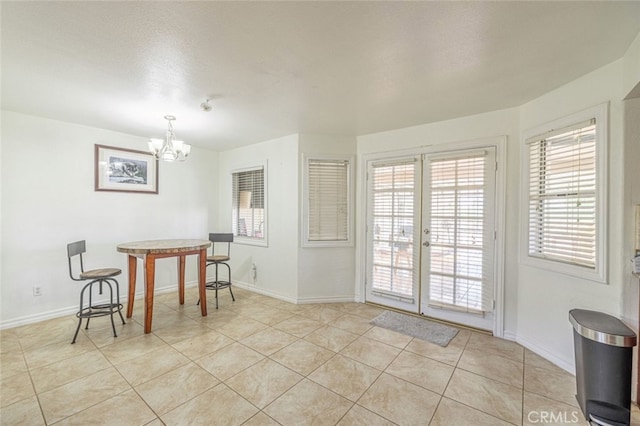 tiled dining space featuring french doors and a notable chandelier