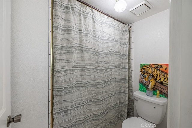 bathroom featuring curtained shower and toilet