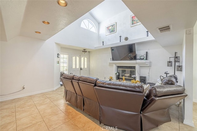 living room with high vaulted ceiling, a textured ceiling, and light tile patterned floors