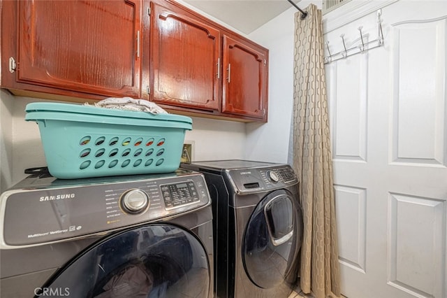 laundry room with cabinets and washer and clothes dryer