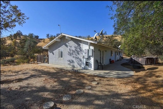 back of property with fence and a patio