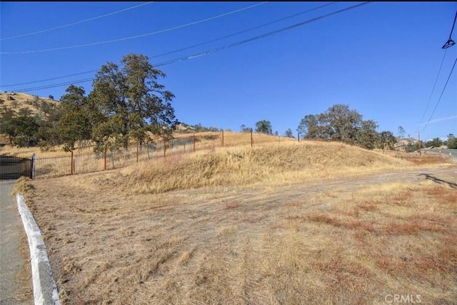 view of yard with a rural view and fence