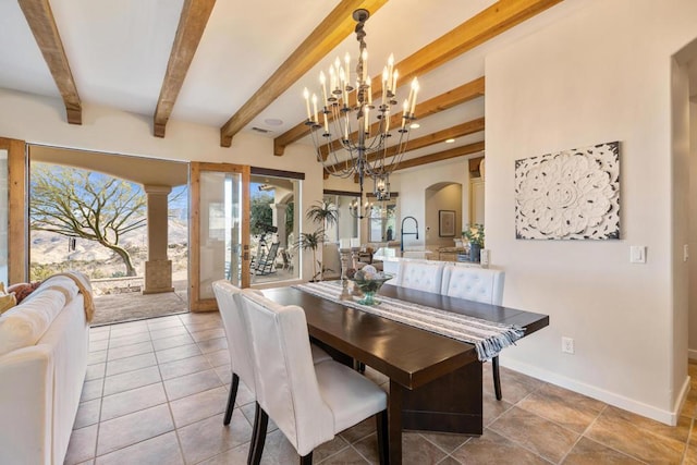 dining area with sink, beamed ceiling, an inviting chandelier, and light tile patterned flooring